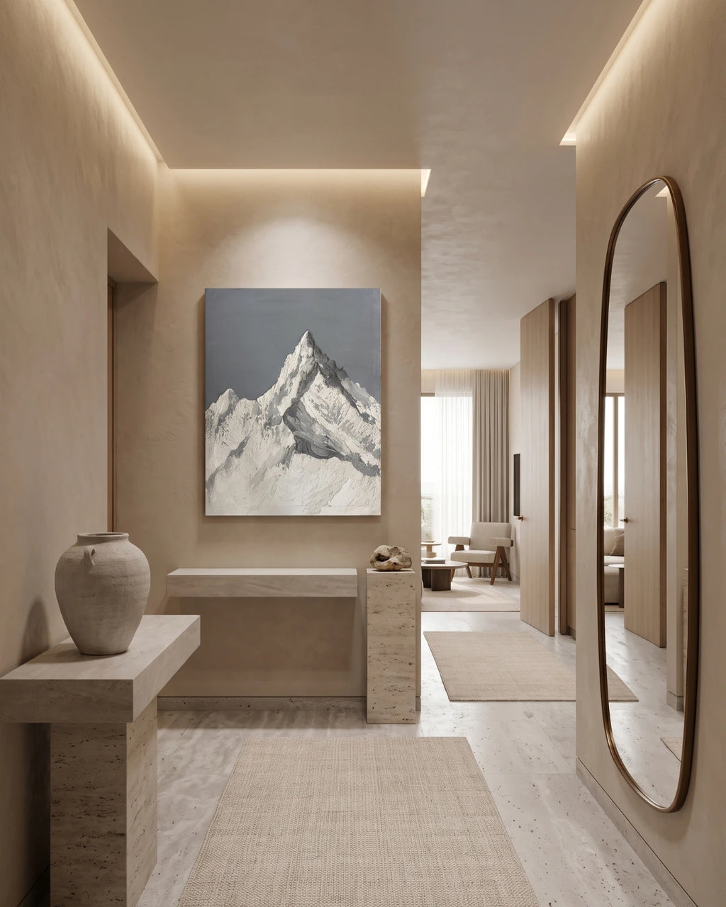 A minimalist interior hallway with warm beige walls and stone-like surfaces, featuring a large framed mountain landscape painting centered on the wall. The artwork depicts a snow-covered mountain peak against a muted blue-gray sky.