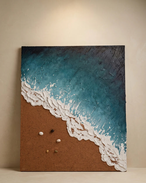 An abstract canvas painting of a beach scene with textured blue and white ocean waves meeting a brown sandy shore, displayed against a neutral beige wall.