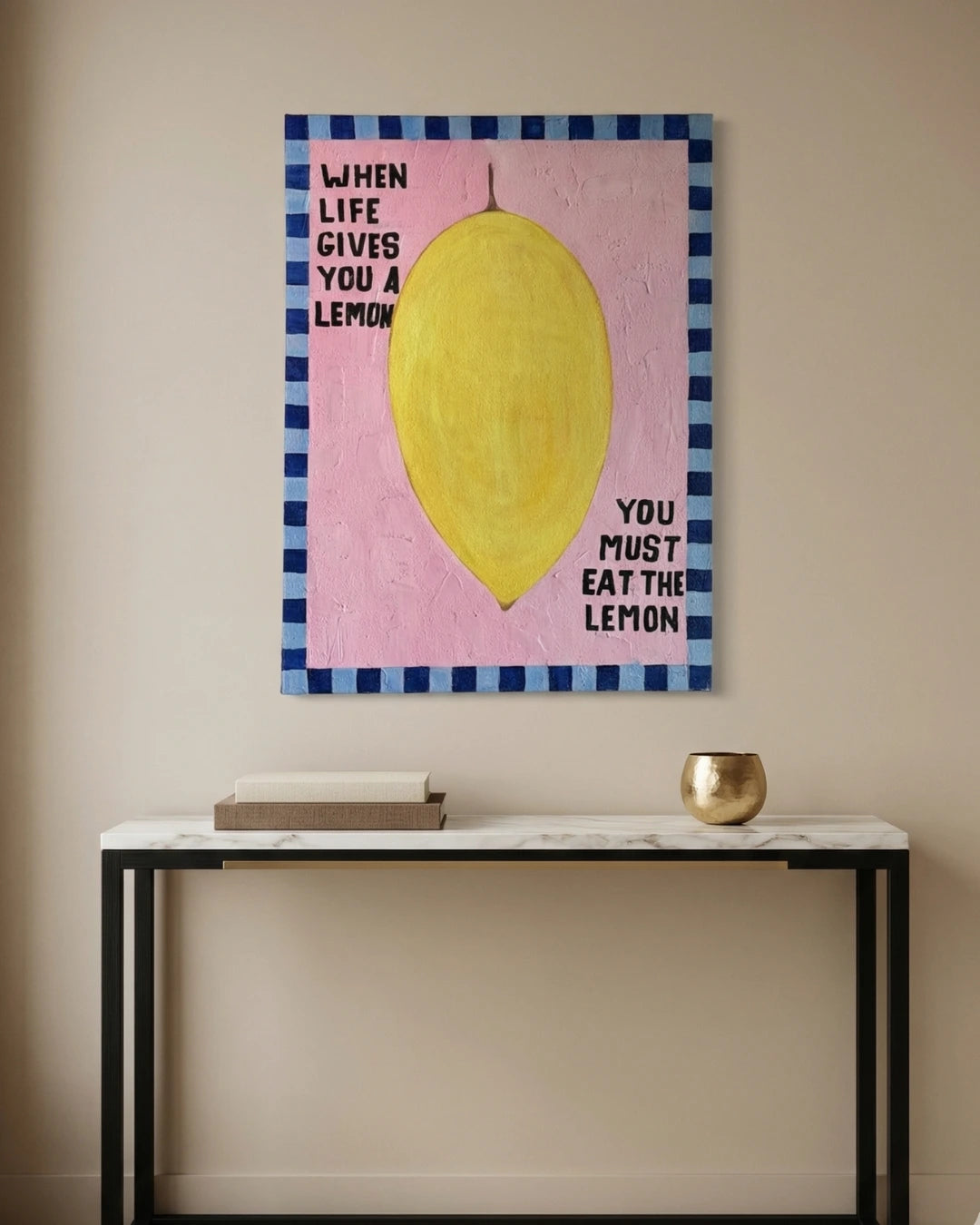 Canvas print with a lemon illustration and text on a wall above a table.