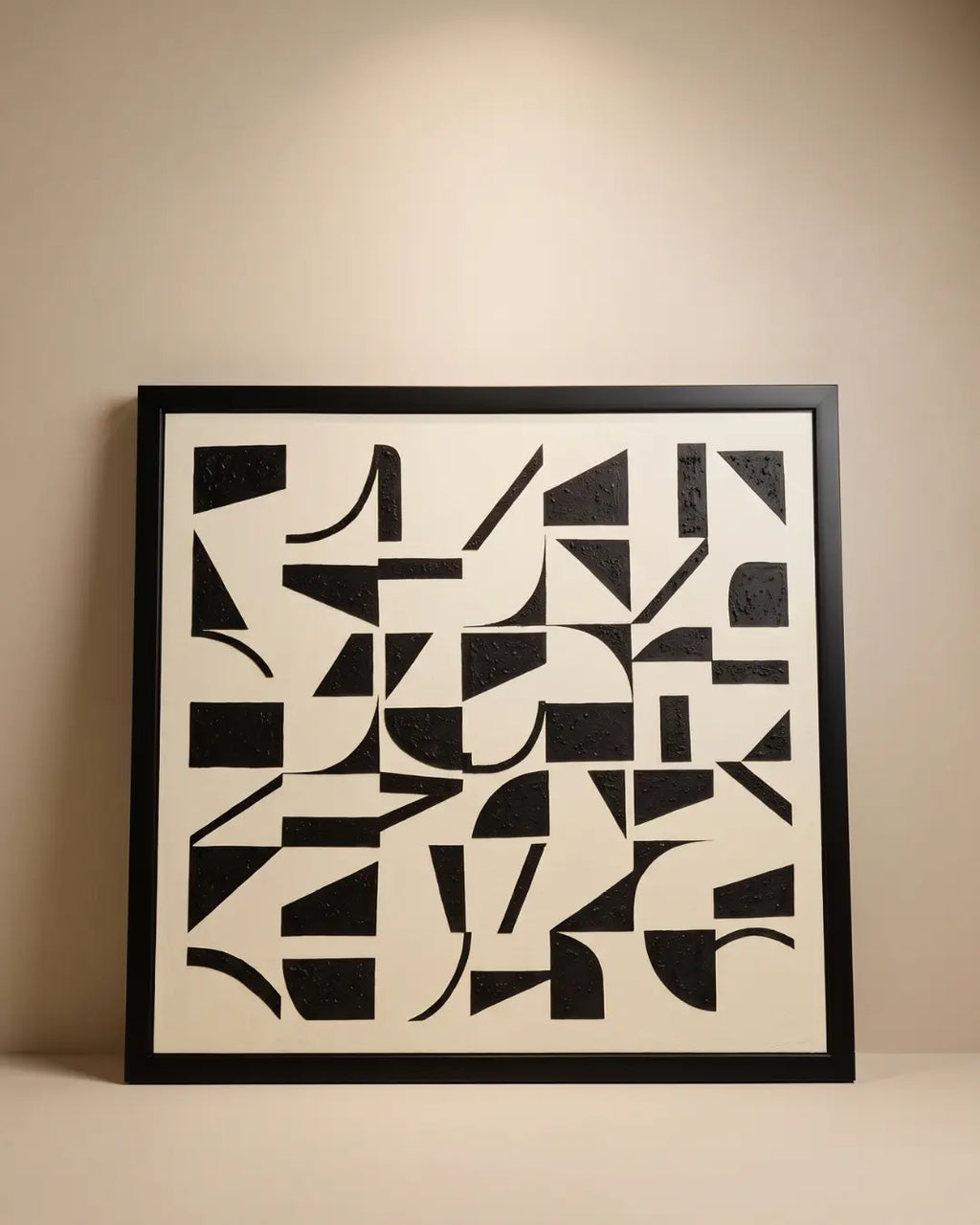 Handmade geometric abstract painting with textured black shapes arranged on a warm beige background in a modern minimalist composition with a black frame.
