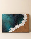 Two-panel aerial ocean textured wall art with teal water and sand shore on plain background, handmade canvas diptych