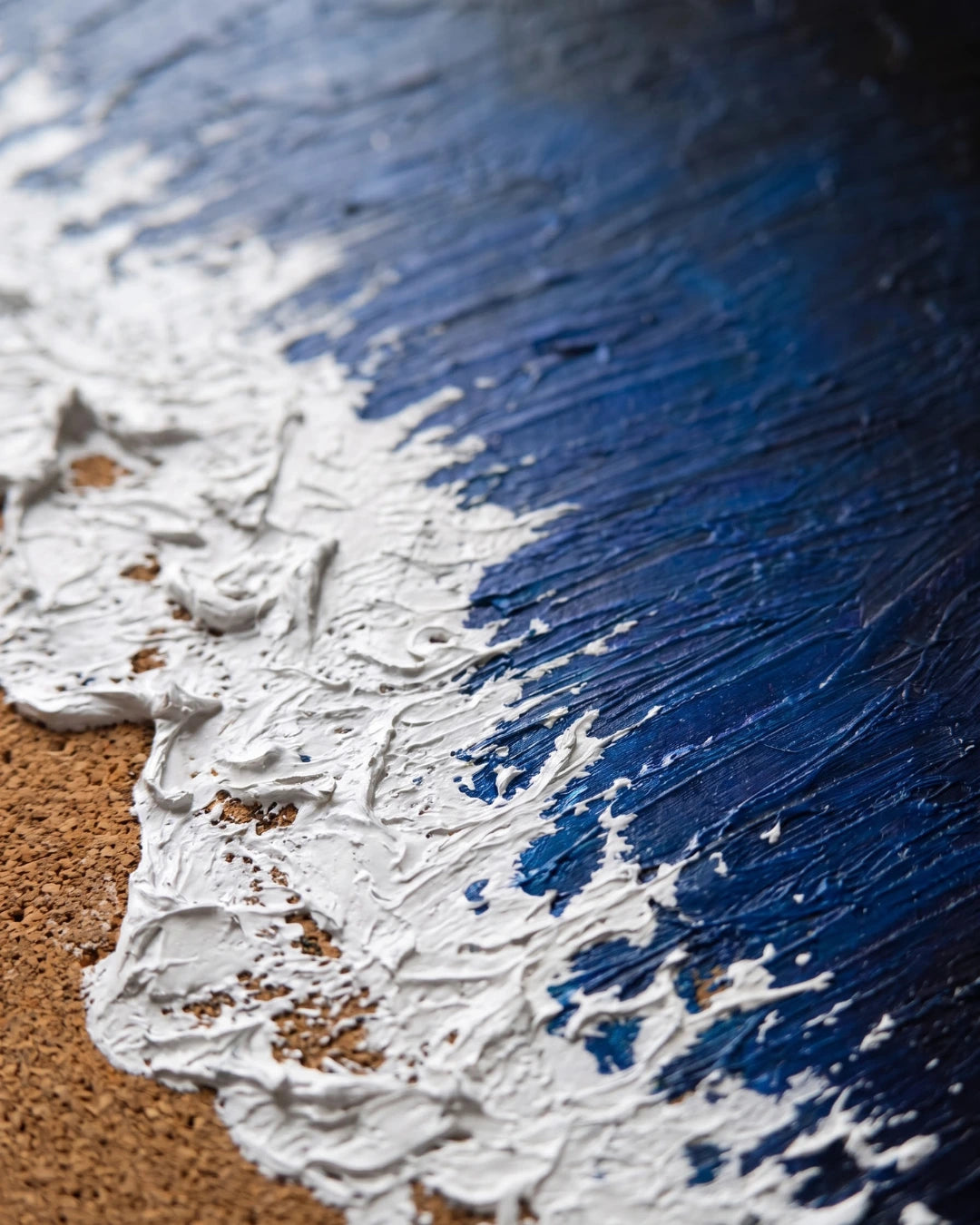 Close-up of Deep Water canvas showing real sand mixed into white foam texture and footprints pressed into painted sand
