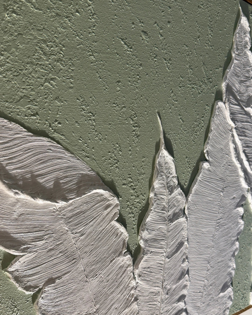 Close-up of a textured painting featuring a muted sage green background with large white feather-like forms rendered in thick impasto brushstrokes.