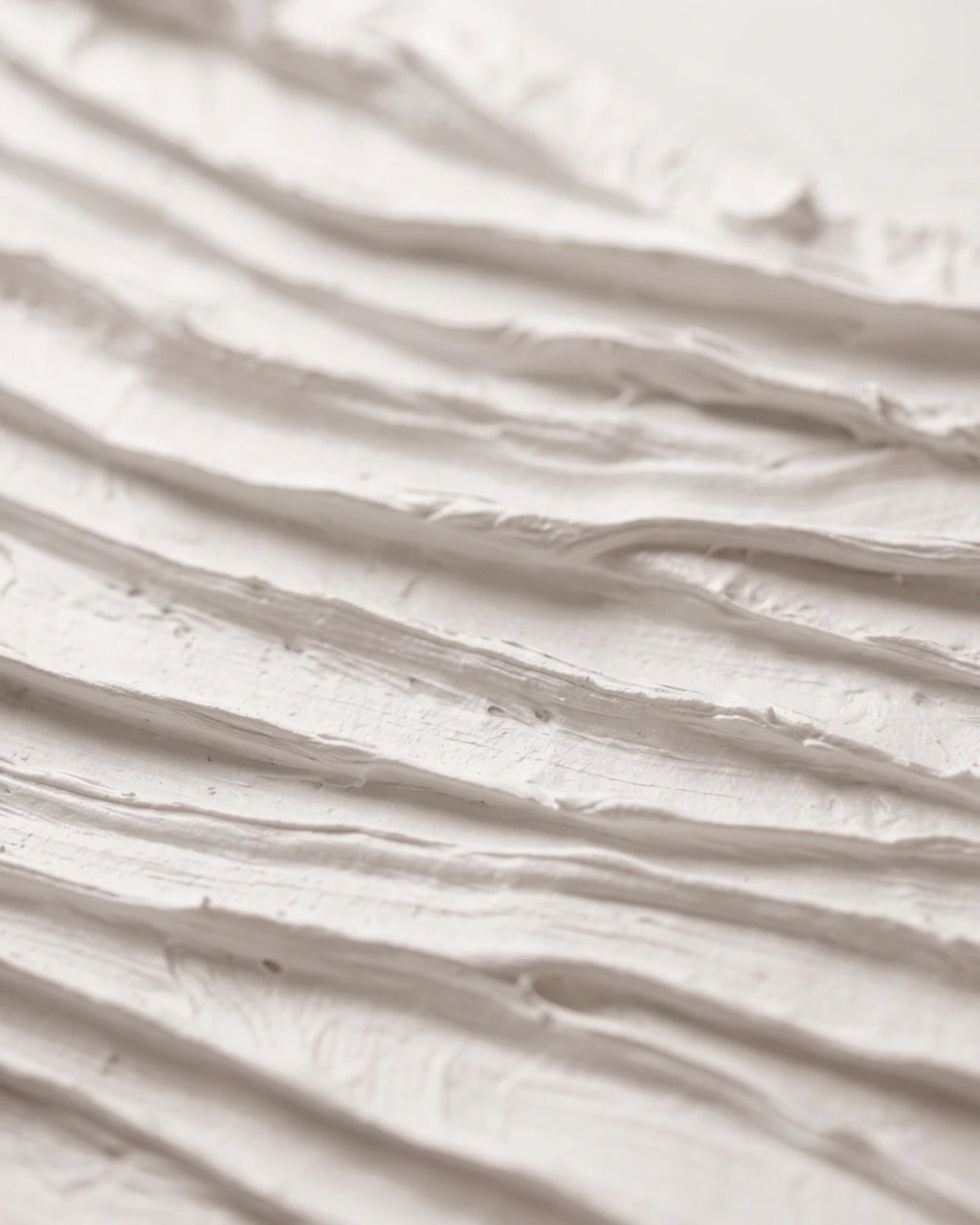 Close-up of Folded White canvas showing deep hand-carved white folds and shadow