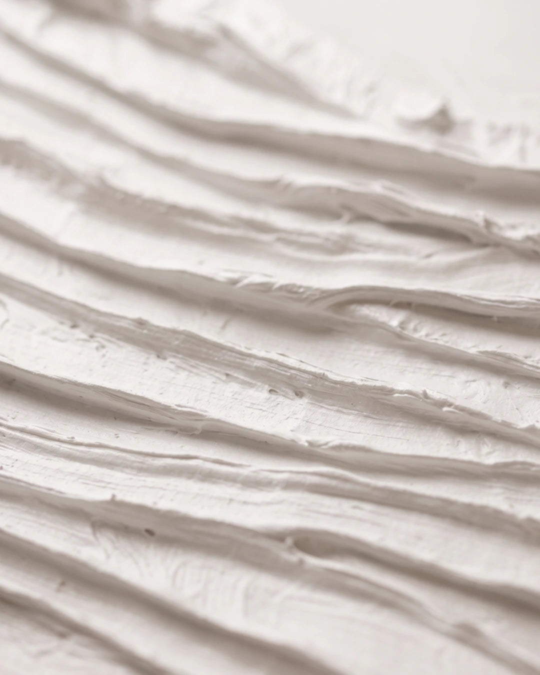 Close-up of Folded White canvas showing deep hand-carved white folds and shadow