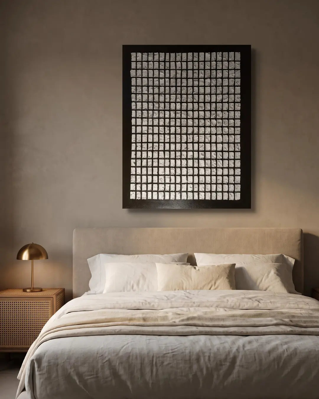 A minimalist bedroom scene featuring a large black-framed wall art piece with a white grid pattern hanging above a neatly made bed with neutral beige and white linens.