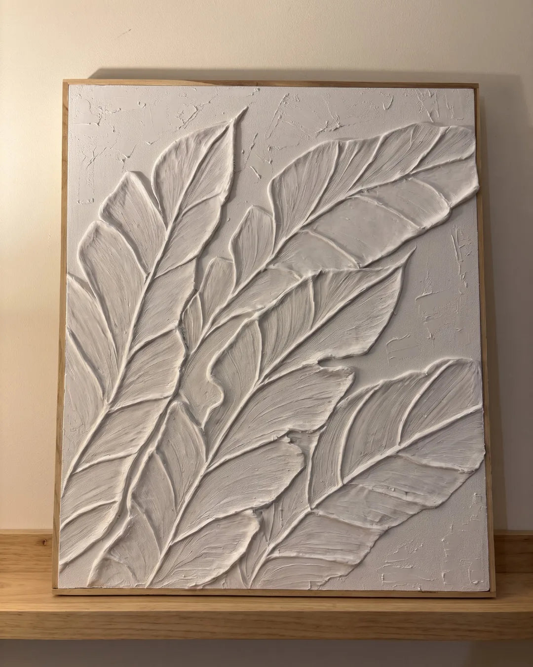 Palm Study white textured painting hanging above a sofa in a modern Indian living room