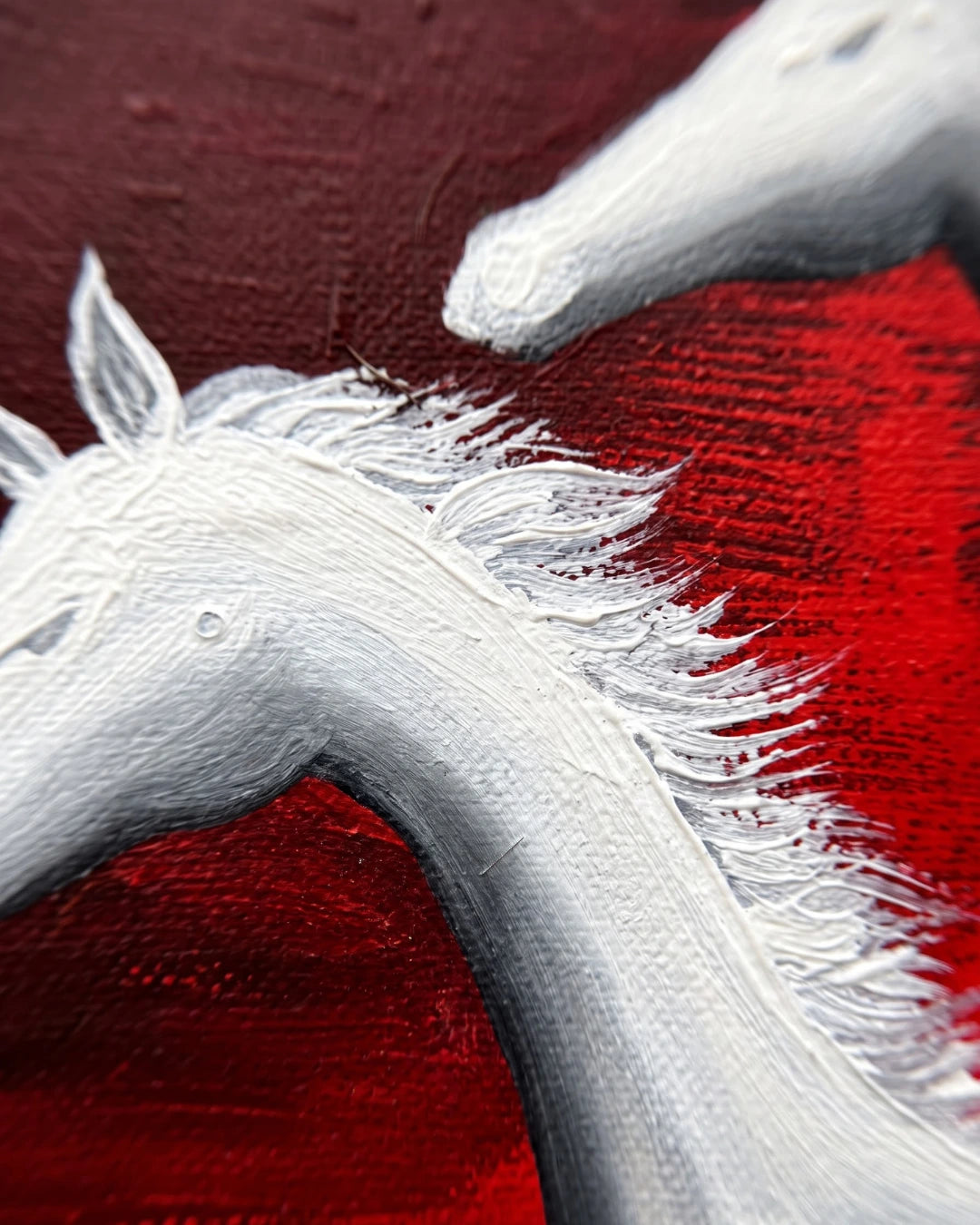 Close-up of Seven Horses canvas showing raised white mane texture against red background