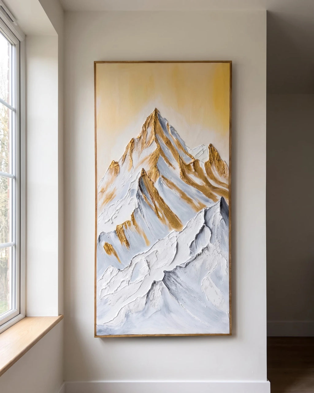Summit Gold mountain painting hanging on a wall beside a window in natural light