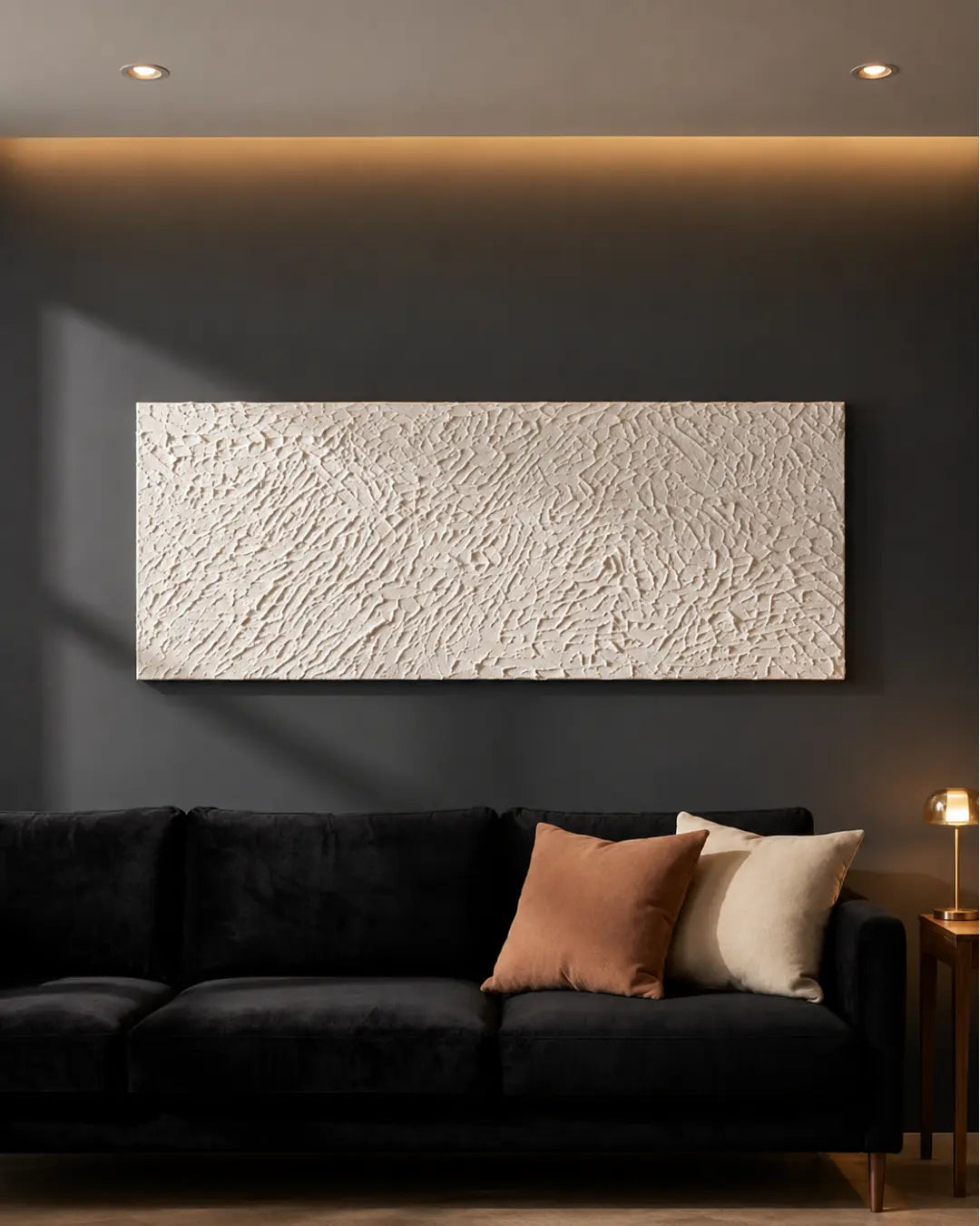 The White Relief ivory textured painting hanging above a dark sofa in a moody living room