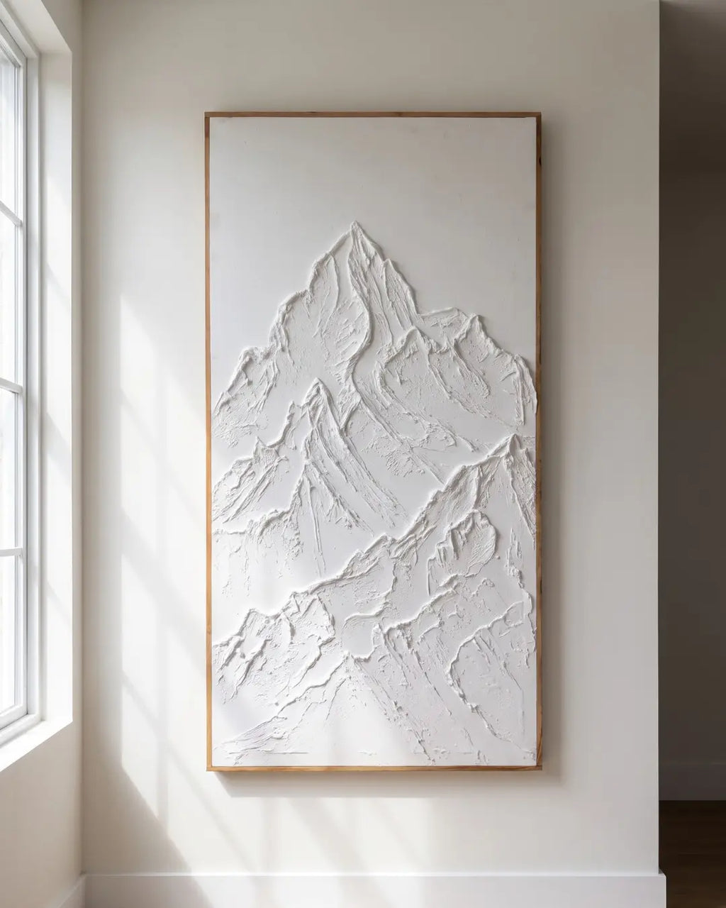 White Peak textured mountain painting hanging on a wall beside a window in natural light